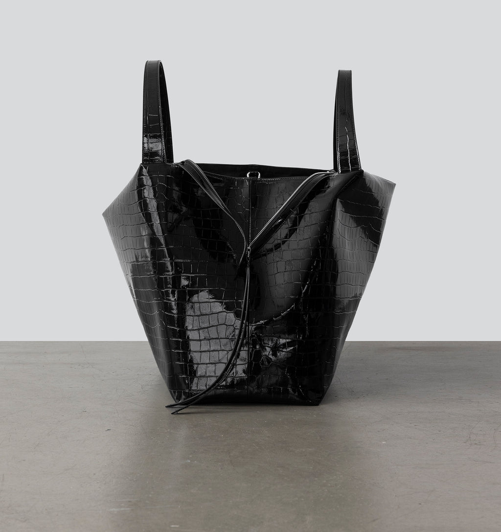 Side view of La Mama LM1, A luxury black lacquer-colored, crocodile-print handbag.