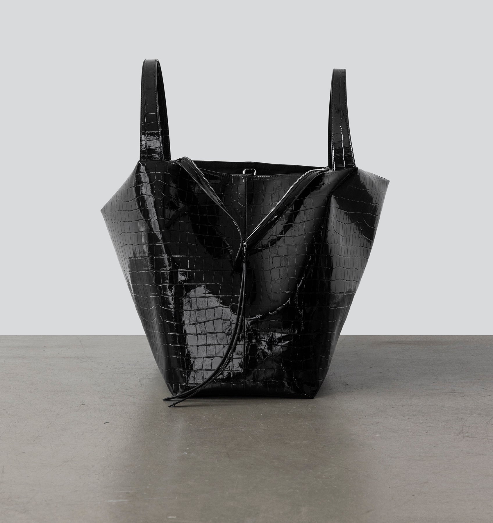 Side view of La Mama LM1, A luxury black lacquer-colored, crocodile-print handbag.