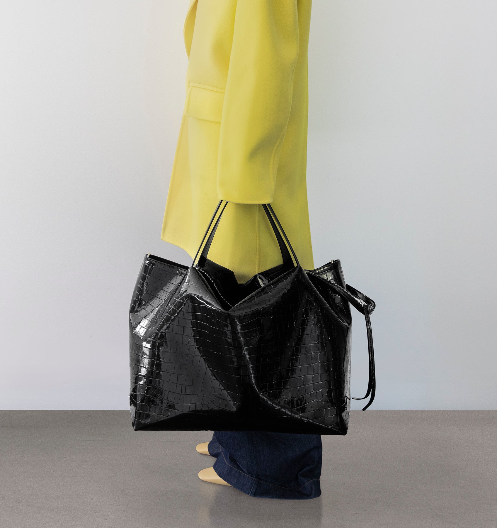 Model carrying the LA MAMA LM1 handbag in Black Lacquer Croco in hand.