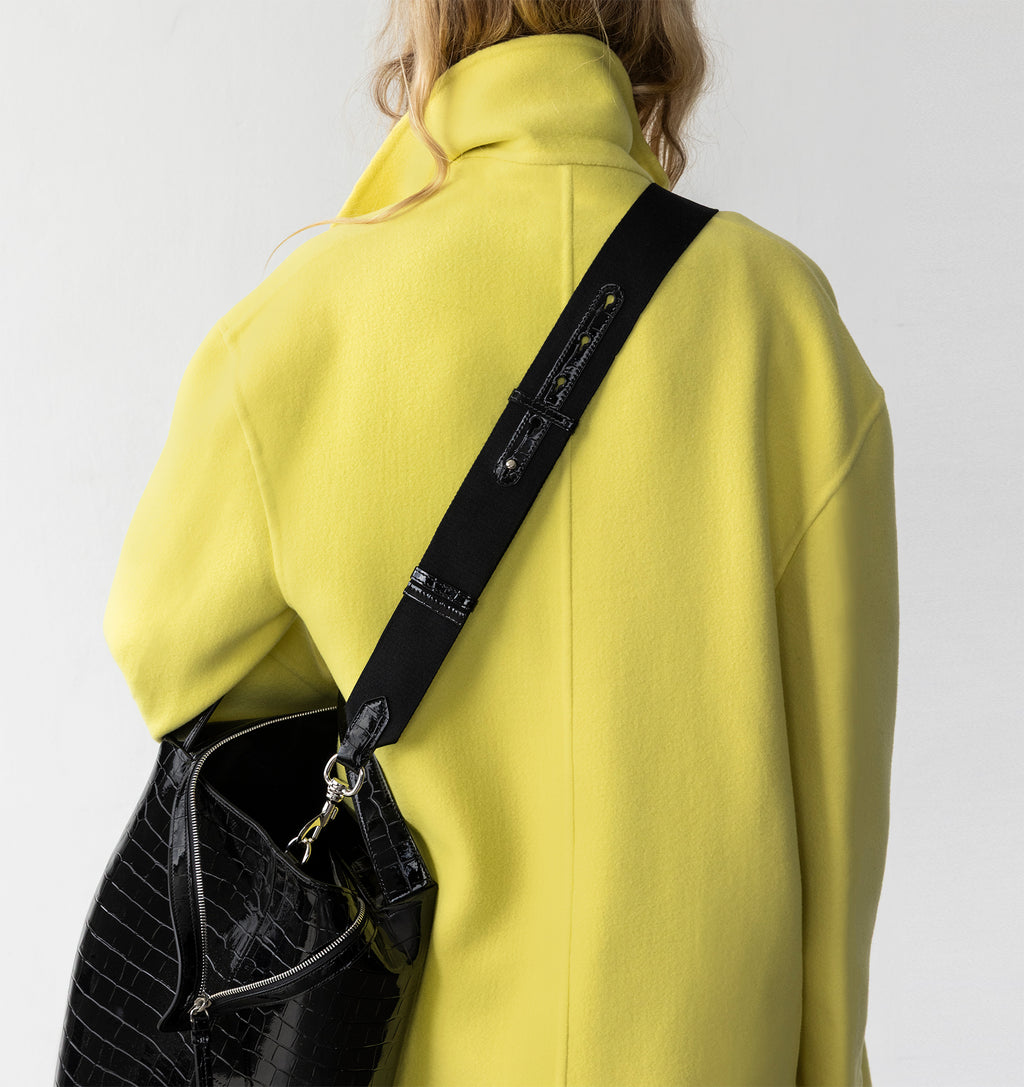 Model wearing the LA MAMA LM1 handbag in Black Lacquer Croco crossbody with the Tracolla.
