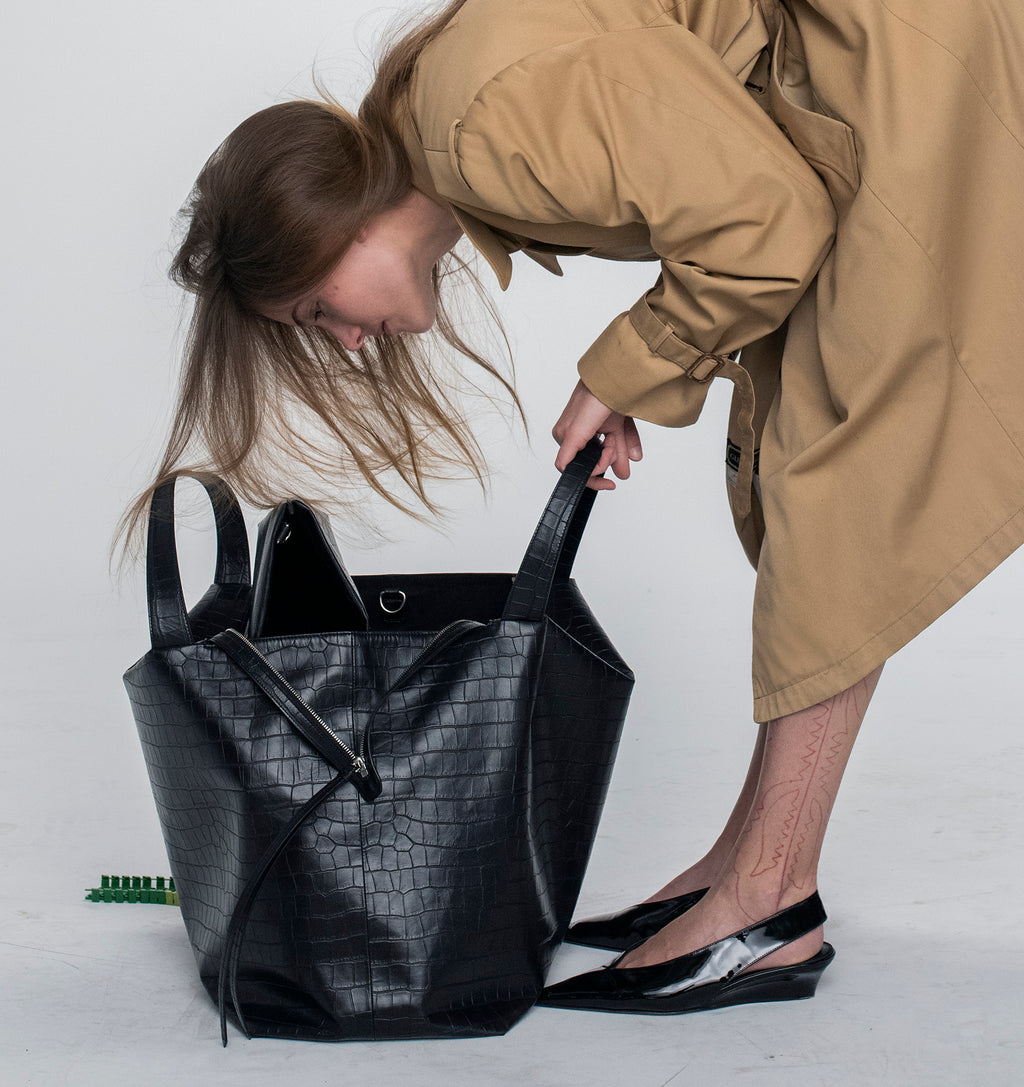 Model with the LA MAMA LM1 handbag in Black Matte Croco on the floor.