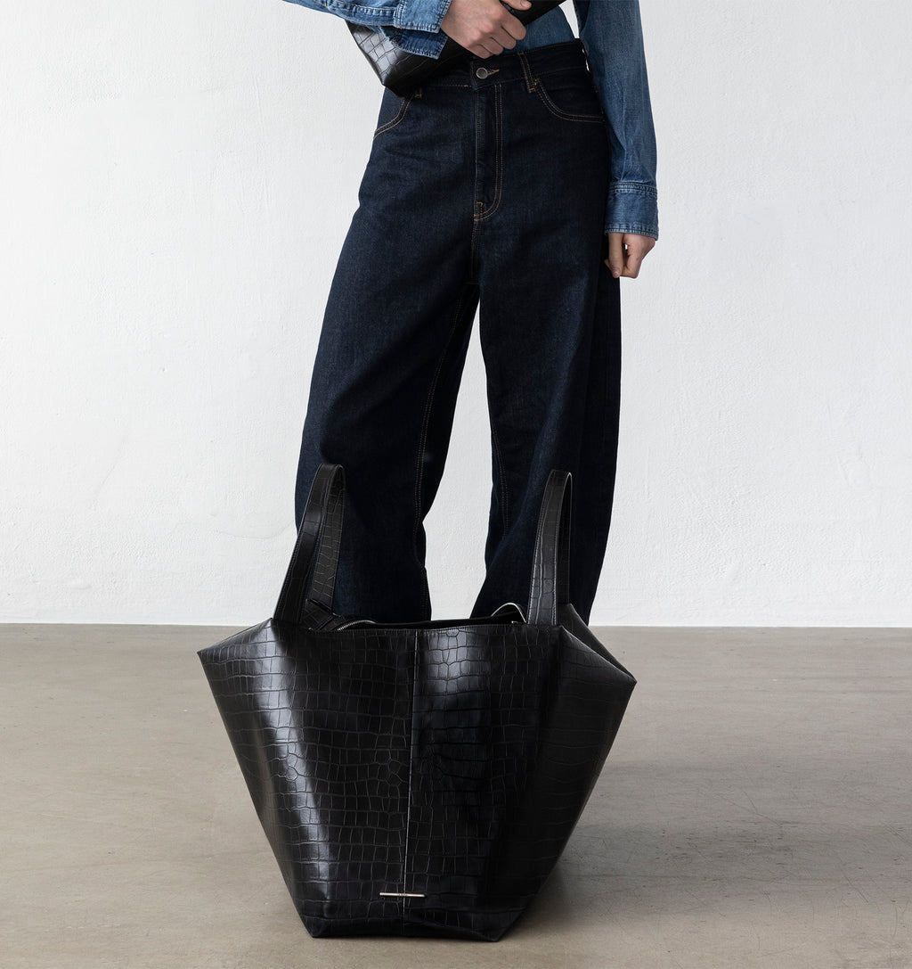 Model with the LA MAMA LM1 handbag in Black Matte Croco on the floor.