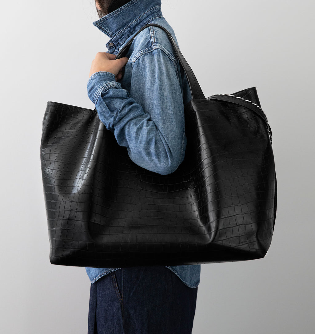 Model carrying the LA MAMA LM1 handbag in Black Matte Croco over the shoulder.
