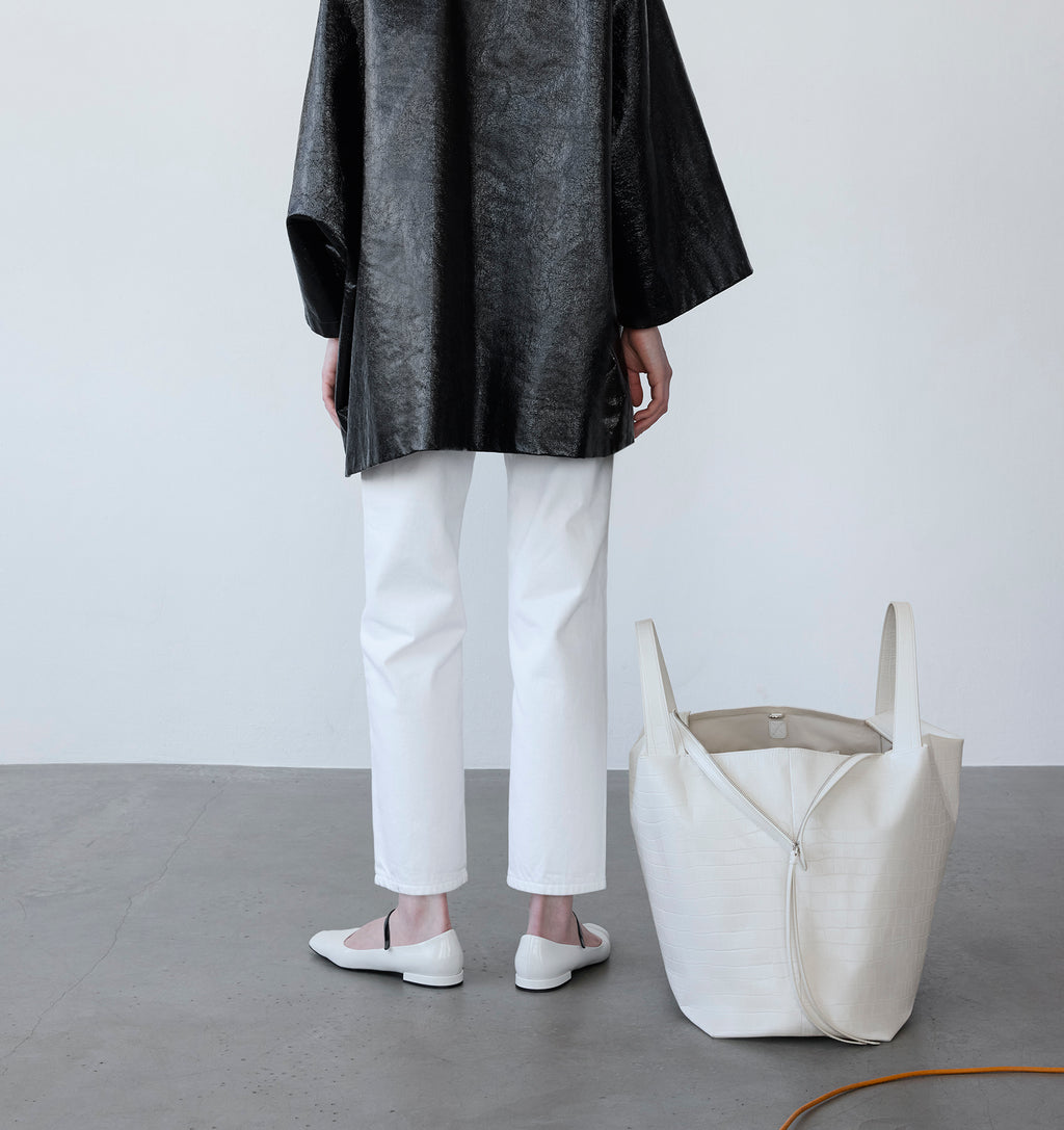 Model with the LA MAMA LM1 handbag in White Matte Croco on the floor.