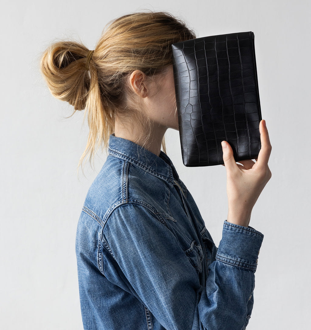 Model carrying the Small Pouch in Black Matte Croco in hand.