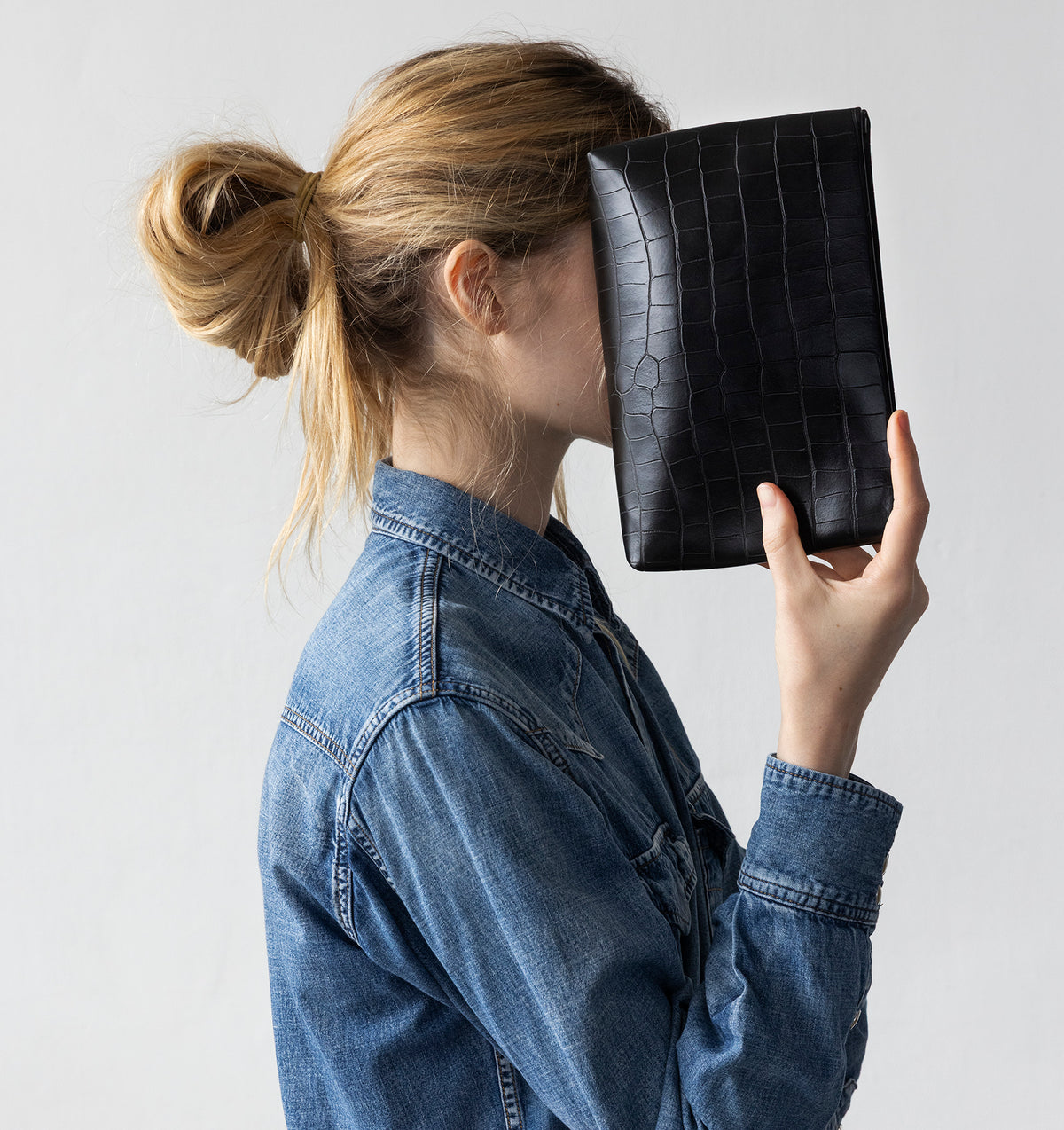 Model carrying the Small Pouch in Black Matte Croco in hand.