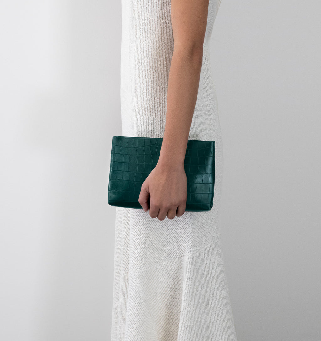 Model carrying the Small Pouch in Green Matte Croco in hand.