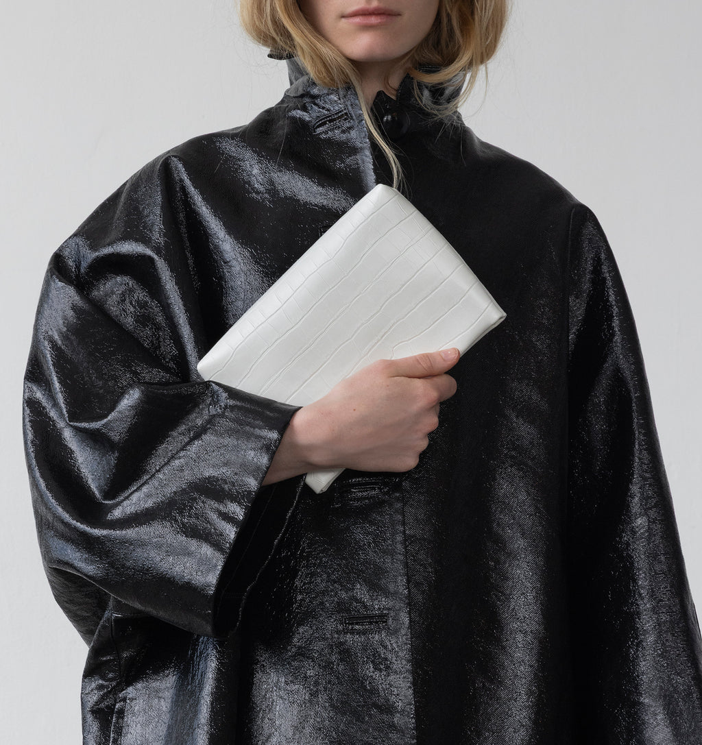 Model carrying the Small Pouch in White Matte Croco in hand.
