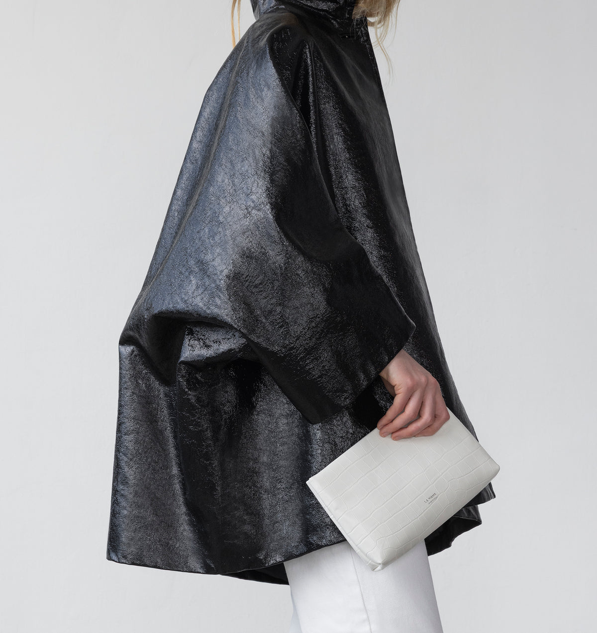 Model carrying the Small Pouch in White Matte Croco in hand.