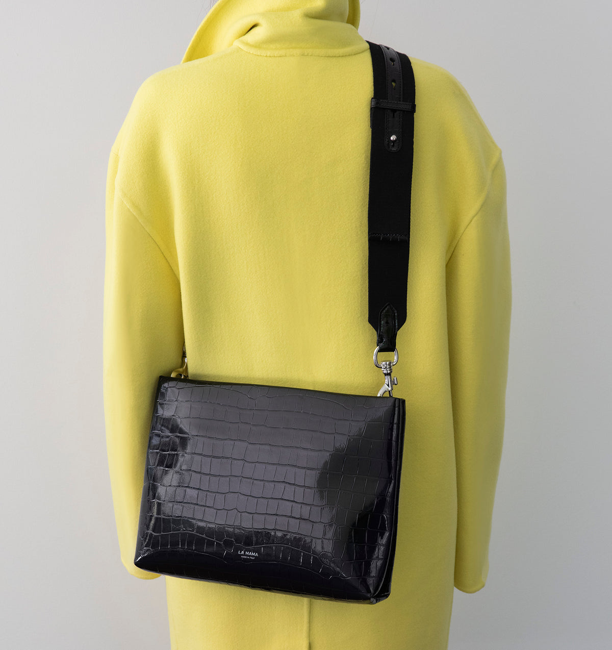 Model wearing the Large Pouch in Black Lacquer Croco crossbody with the Tracolla.