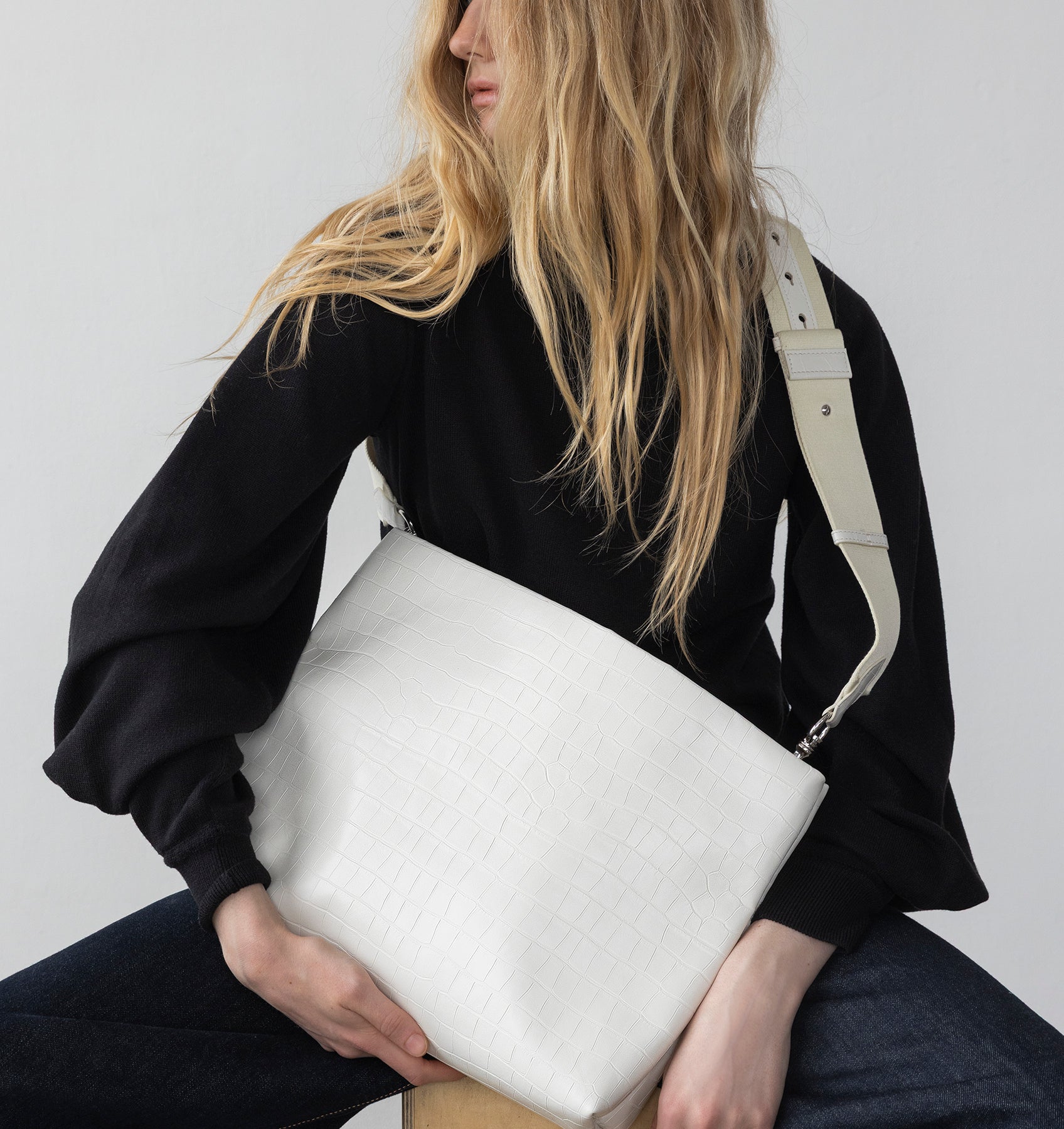 Model wearing the XL Pouch in White Matte Croco crossbody with the Tracolla.