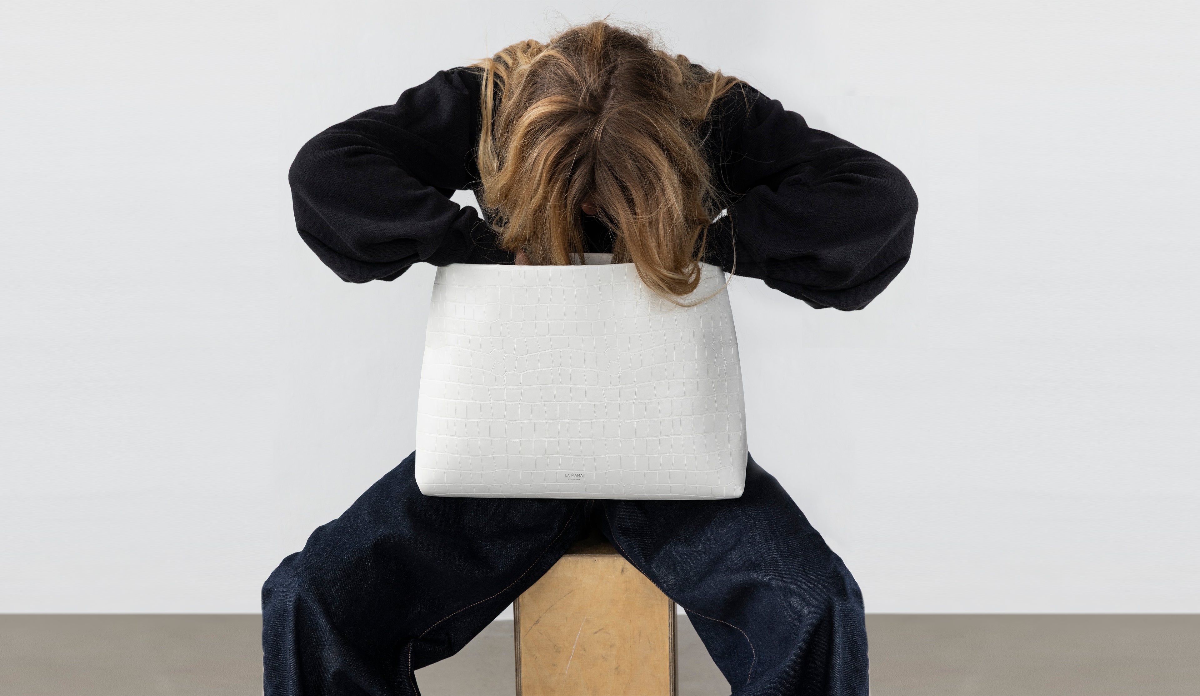 Model carrying the XL Pouch in White Matte Croco in hand.